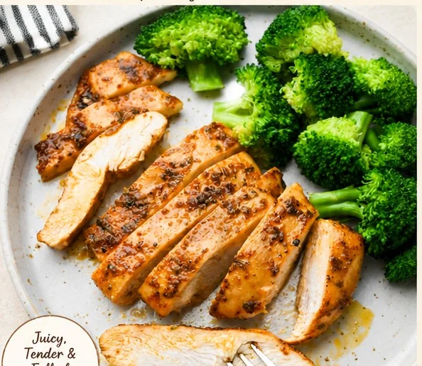 Juicy baked chicken breast served with fresh vegetables and herbs.