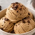 Delicious coffee ice cream served in a bowl with coffee beans around it