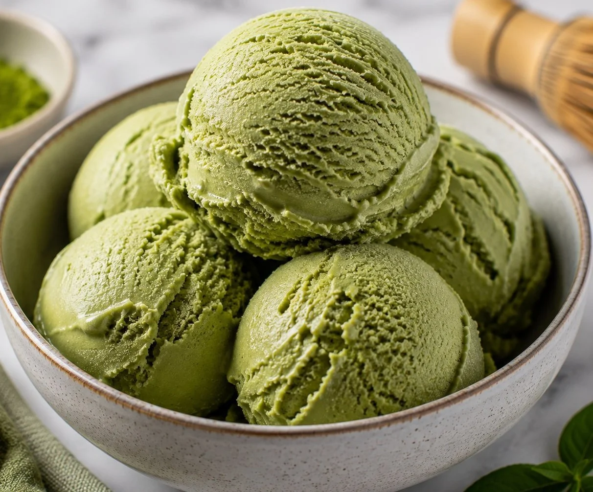 Creamy matcha ice cream served in a bowl with green tea leaves