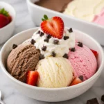 Three flavors of Neapolitan Ice Cream: chocolate, vanilla, and strawberry in a bowl.